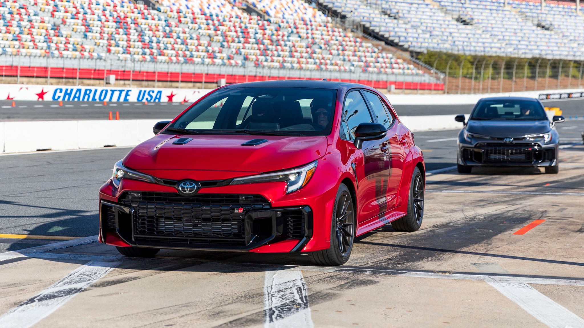071a6494-1 Photo of a red Toyota GR Corolla on a racetrack pit lane.