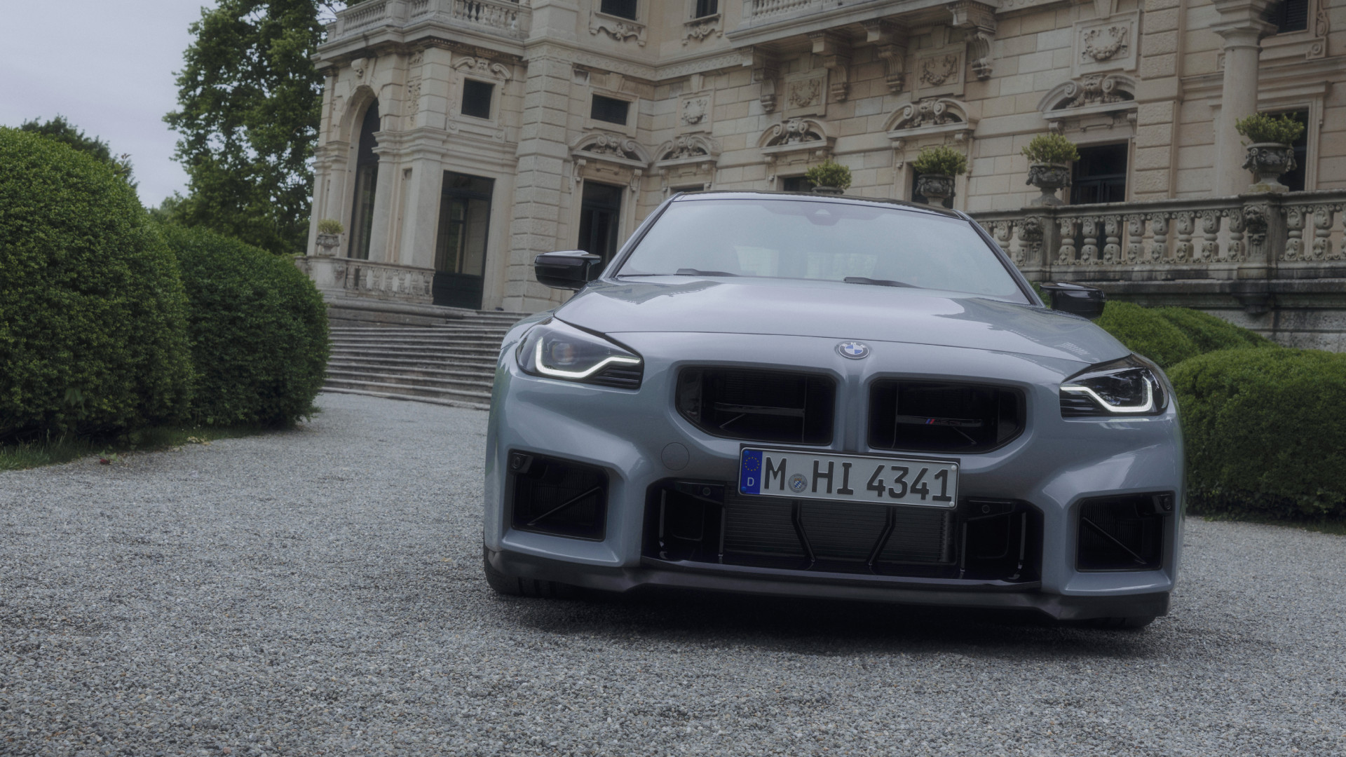 p90600960-highres 2026 BMW M2 CS in front of a lakeside estate.