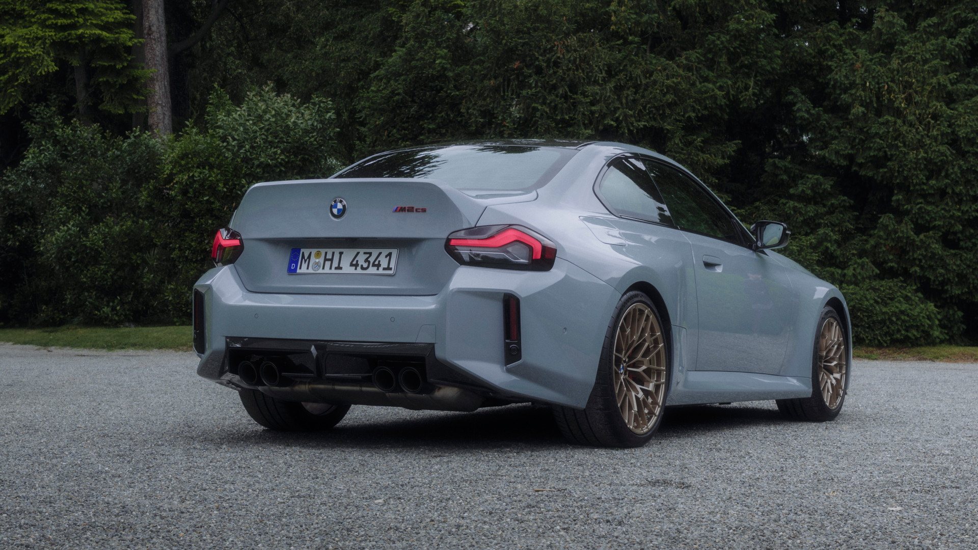 p90600965-highres 2026 BMW M2 CS in front of a lakeside estate, rear view.