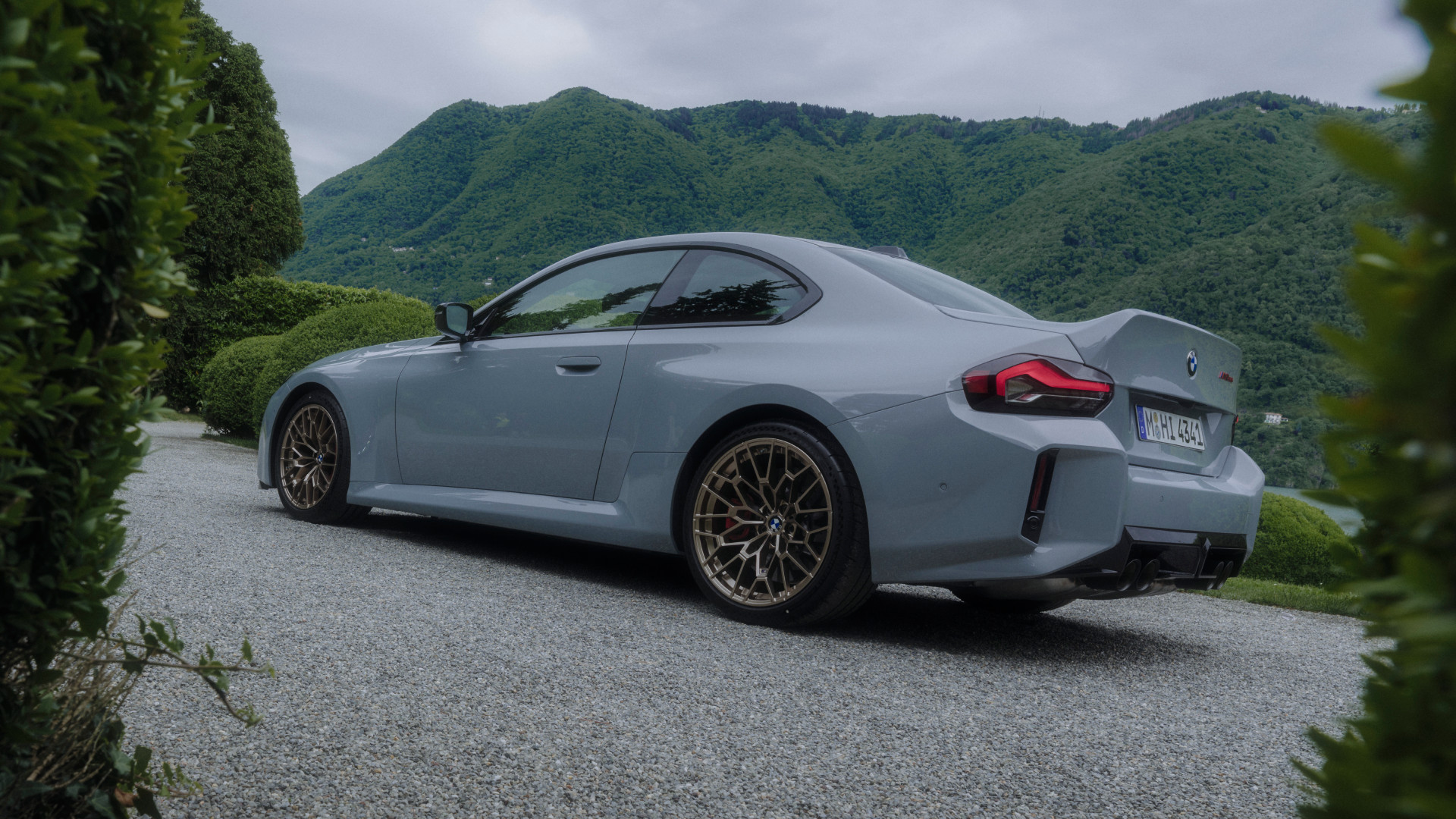 2026 BMW M2 CS in front of a lakeside estate, rear view.