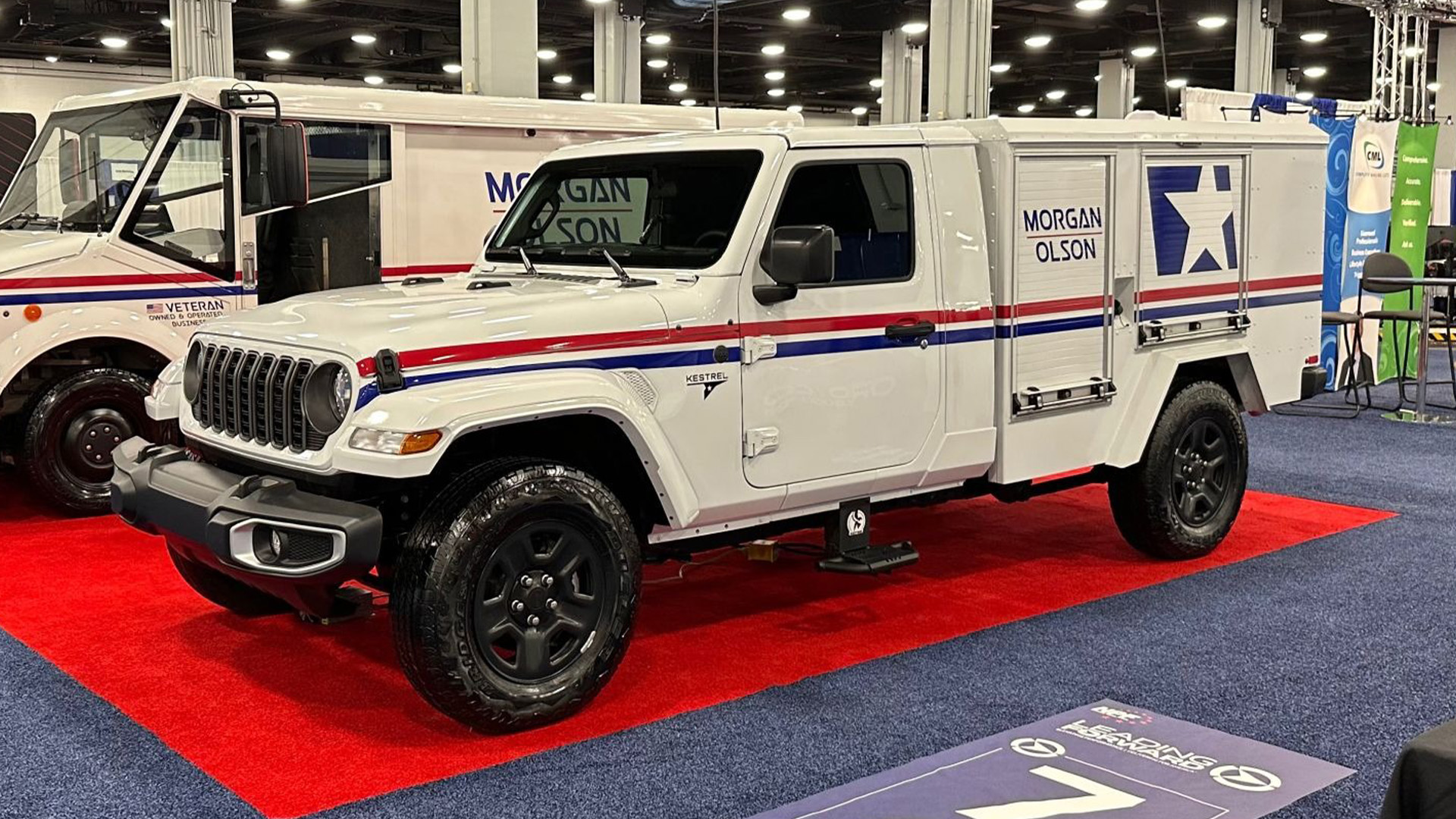 postal-jeep-hero-3-1 A Jeep Gladiator postal vehicle sits parked in an exhibition center.