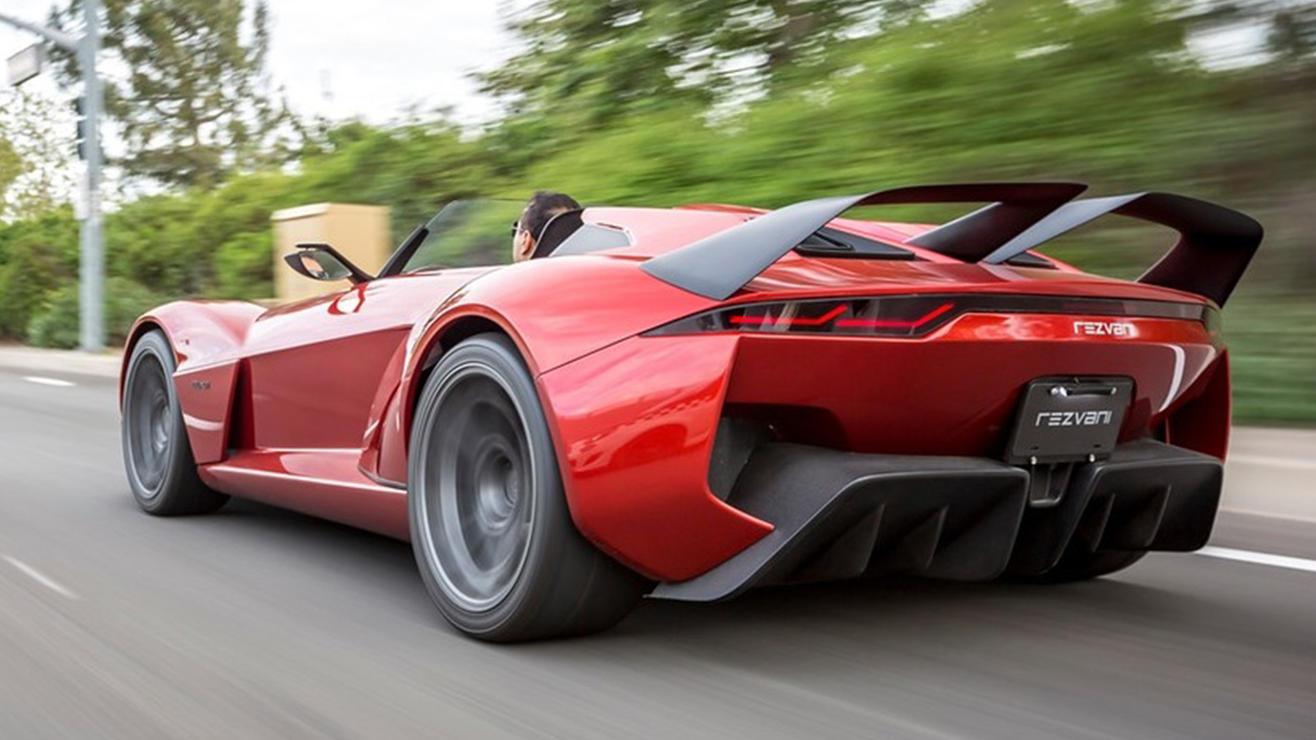 rezvani-beast-hero-2-1 A Rezvani Beast sports car drives down the road with its top down.