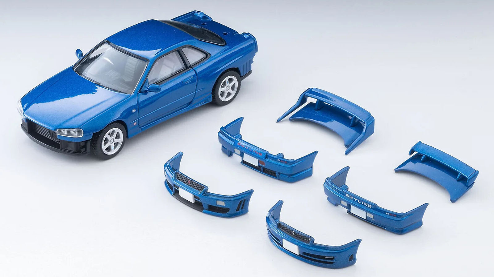 2117848-copy-1 Tomy Tomica Limited Vintage Neo 1/64 scale model of Nissan Skyline 25GT Turbo Coupe (R34) with all its parts laid next to it.