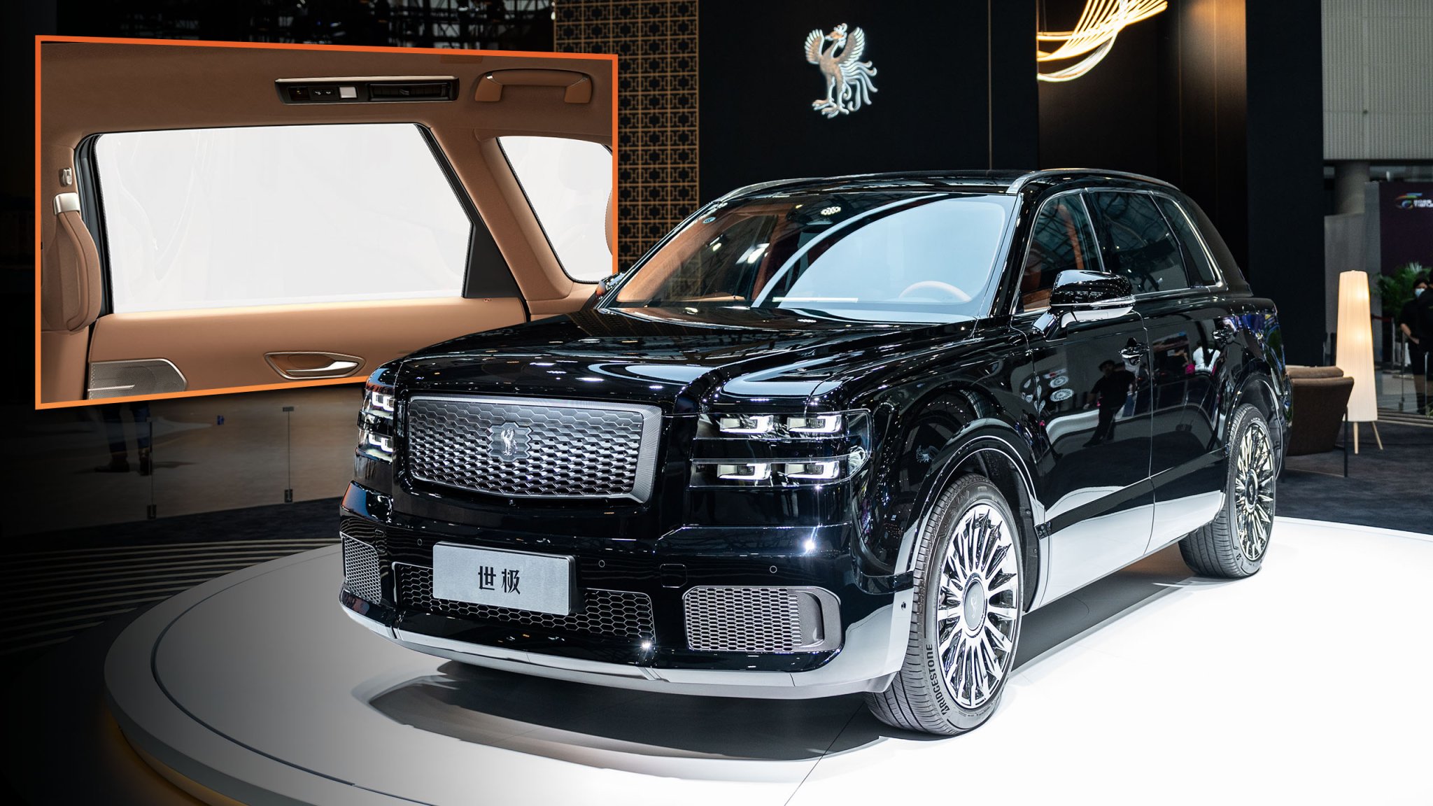 gettyimages-2185073302-copy-1-1 An image of the Toyota Century SUV at an auto show with a picture of its opaque side glass behind it.