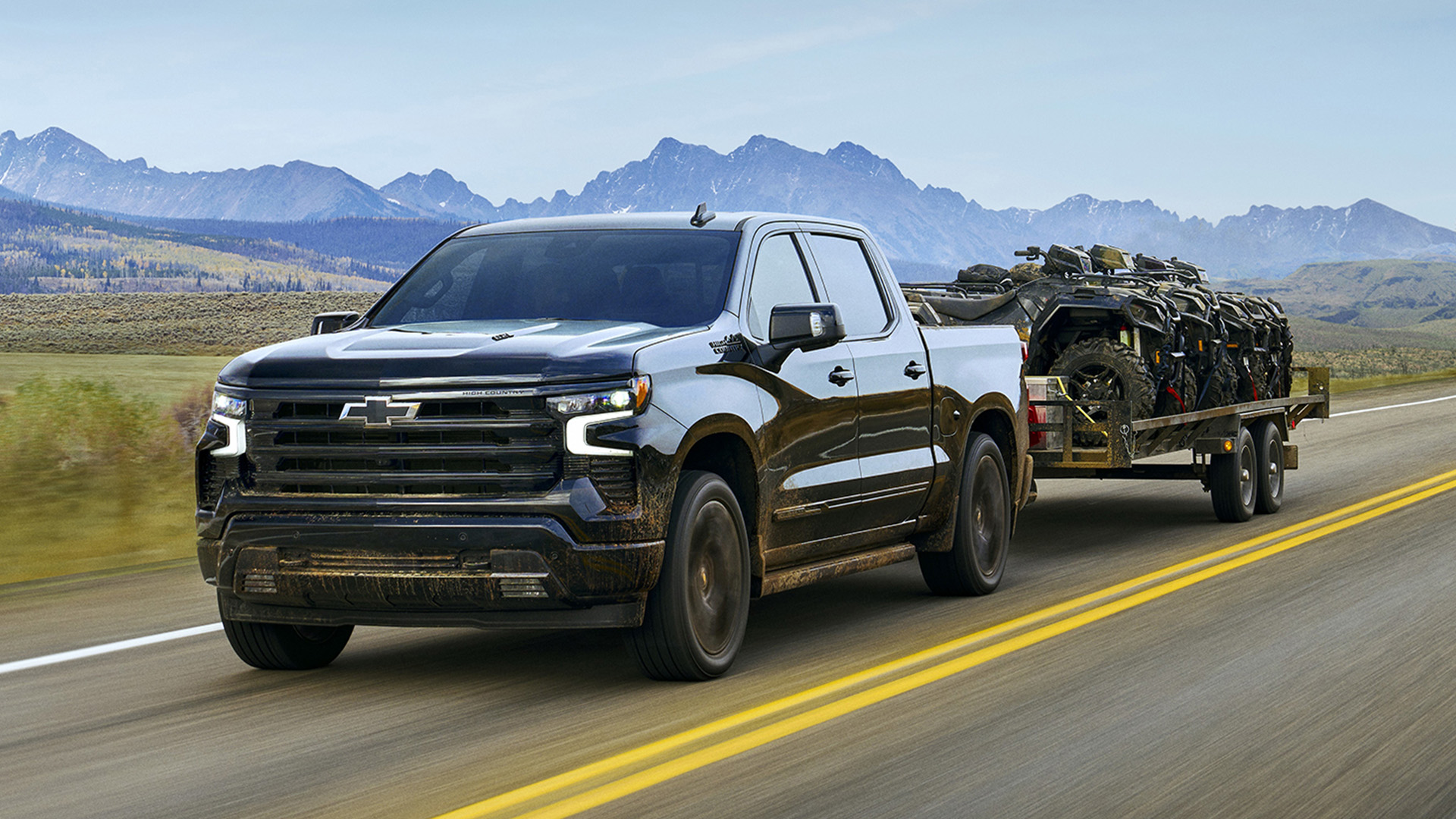 gm-small-block-v8-hero-1-1 A Chevrolet Silverado pickup truck tows a trailer loaded with ATVs.